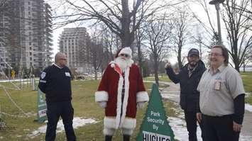 Members from Hughes Intelligence and GardaWorld stand alongside Santa Claus at the Celebration of Lights display in Sarnia's Centennial Park. 3 December 2020. (BlackburnNews.com photo by Colin Gowdy)