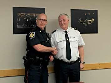 Police Chief Phil Nelson presents the retiring Constable Les Jones with the 'Chief's Coin'. January 28, 2016 (BlackburnNews.com Photo by Briana Carnegie)