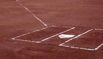 A close-up of the batters boxes and home plate on a vacant baseball diamond. © Can Stock Photo / ca2hill