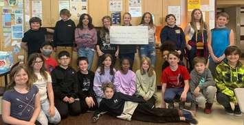 Students in the Grade 5/6 class at St. Matthew Catholic School with a cheque for $1,166, which they presented to St. George Catholic Ukrainian Church. (Photo courtesy of the St. Clair Catholic District School Board.) 