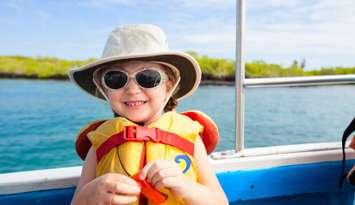 A young child on a boat in a lifejacket. Photo by shalamov/ iStock via Getty Images Plus.