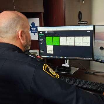 Insp. Michael Van Sickle looking at the new biometric monitoring system (Photo by: Sarnia police)