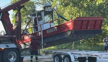 A worker with Preferred Towing lifts Marine 1 onto a trailer after retrieving the vessel from the Lake Huron shoreline. July 21, 2025 Submitted photo.