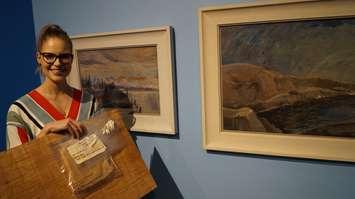JNAAG  Assistant Curator Sonya Blazek show tools used to restore two recently donated Emily Carr paintings behind her. June 29, 2017 (Photo by Melanie Irwin)