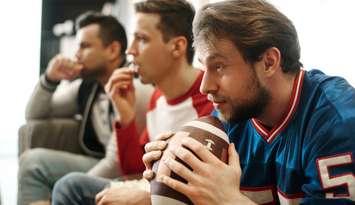 People watching a football game stock photo (Photo by: gpointstudio/  iStock / Getty Images Plus) 