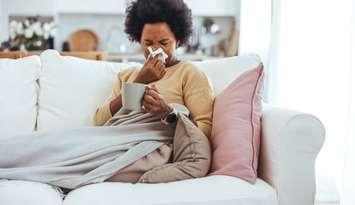 A woman blowing her nose while sick (Photo by: dragana991/ 	iStock / Getty Images Plus)