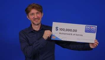 Muhamed Becirspahic show off his big cheque after claiming an ENCORE win. Photo courtesy of OLG.