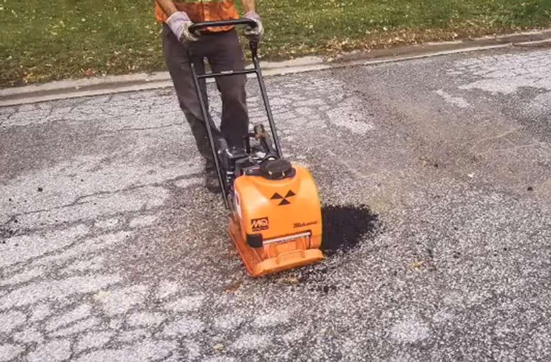 Sarnia Public Works Department staff use equipment to compress hot asphalt to fix a pothole. Image courtesy of Sarnia City Councillor George Vandenberg. 