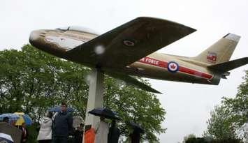 Mike Bradley and Chris Hadfield look on as a plaque is unveiled rededicating the Golden Hawk at Germain Park May 31,2015 (BlackburnNews.com photo by Dave Dentinger)
