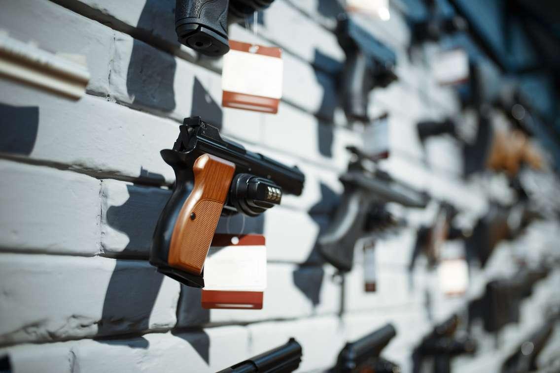 Handguns on showcase in gun shop closeup. © Can Stock Photo / NomadSoul1