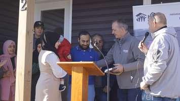 Habitat for Humanity Sarnia-Lambton Board Chair Martin Vrolyk gives keys to Abdullah Alkhalifa and his wife Badour Alzuh. December 8, 2023. (Photo by Natalia Vega)