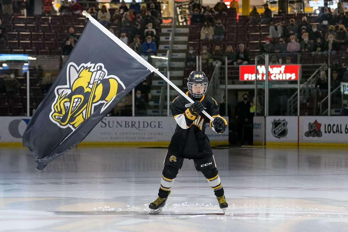 A young skater waves a Sarnia Sting flag prior to puckdrop.  21 February 2022. (Metcalfe Photgraphy)