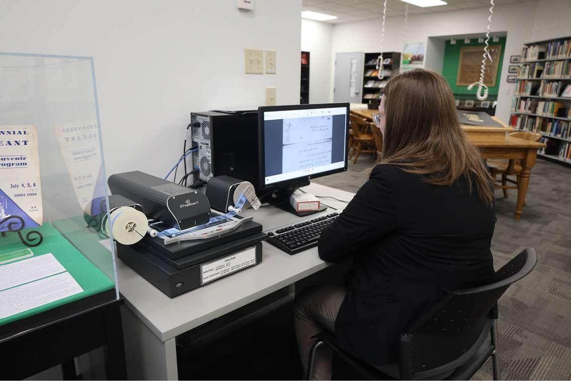 A visitor browses a Moore Township Paper on microfilm. (Photo by: County of Lambton)