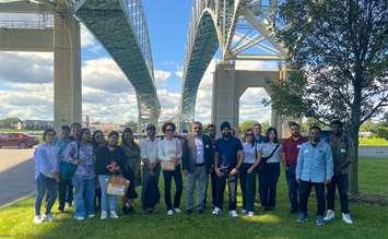 Participants in the Sarnia-Lambton Economic Partnership Newcomer Connection Program gather beneath the Blue Water Bridge. Photo courtesy of SLEP.   
