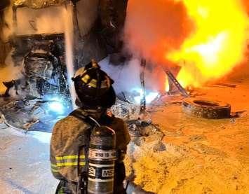 A firefighter works to extinguish a Highway 402 crash Wednesday, Mar 26. Photo courtesy of Sarnia Fire and Rescue Services.