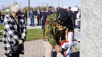 Community members place poppies in front of the Aamjiwnaang cenotaph. November 10, 2023. (Photo by Natalia Vega)