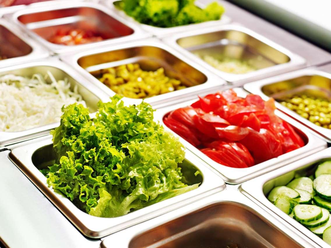 Tray with food on showcase at cafeteria. © Can Stock Photo / Geleol