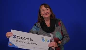 Sarnia's Christine Doyle shows off the cheque she received after claiming a LOTTO MAX win. Image courtesy of the OLG.