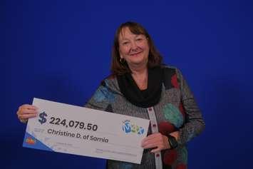 Sarnia's Christine Doyle shows off the cheque she received after claiming a LOTTO MAX win. Image courtesy of the OLG.