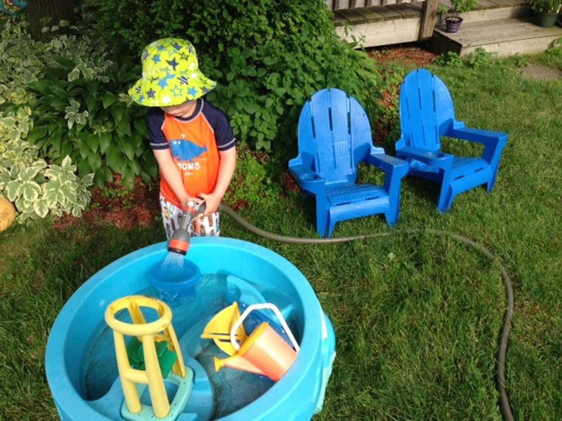 A little boy cools off playing at a water table on a hot summer day. BlackburnNews.com (Photo by Melanie Irwin)