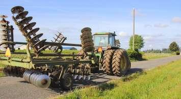 Farm equipment moving on rural road (Image courtesy of Getty Images/Modfos)