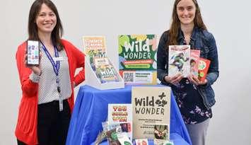 Lambton County Library staff members Adrianne Lebert (left) and Vanitia Campbell showcase materials for Lambton County Library's "Wild Wonder" Summer Reading Challenge, including book prizes and registration kits. Submitted photo.