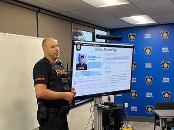 Sarnia Police Cst. Tyler Callander explains his new role as the Aamjiwnaang Community Centre. 27 July 2023. (Photo by Sarnia News Today)