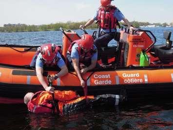 Canadian Coast Guard Inshore Rescue Boat crew retrieves a man from the water during recent training in Trenton, Ontario. May 2016. Submitted photo.