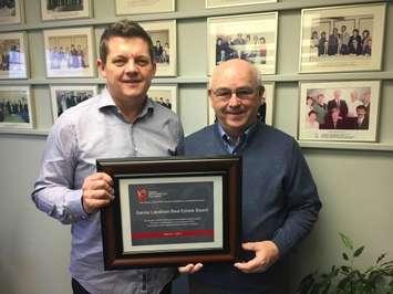 Sarnia-Lambton Real Estate Board President Steve Park and Executive Officer David Burke show off their award from the Ontario Realtors Care Foundation. April 6, 2017 BlackburnNews.com photo by Melanie Irwin