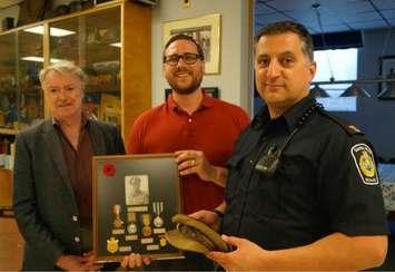 Sarnia Mayor Mike Bradley, Historical Society President Ron Reale-Smith and Sarnia Police Constable John Sottosanti show off a collection of personal effects from George Smith donated recently. May, 2017 (Photo by Melanie Irwin)