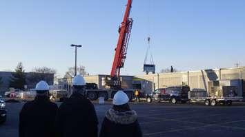 (From left to right) MPP Bob Bailey, Tim Bechard and Karen McClintock watch an HVAC system being lifted onto the roof of Pathways Health Centre for Children. 21 December 2022. Photo by Blackburn Media.  