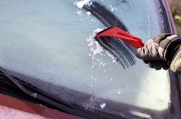 Scraping ice from the car window on a cold day. © Can Stock Photo / Cebas