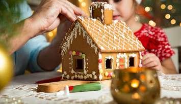 A gingerbread house being built (Photo by: Suzi Media Production/ iStock / Getty Images Plus)