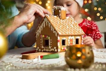 A gingerbread house being built (Photo by: Suzi Media Production/ iStock / Getty Images Plus)