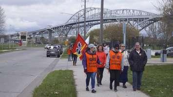 Striking federal public workers walking along Venetian Boulevard in Point Edward. Wednesday, April 26, 2023. (Photo by Natalia Vega)
