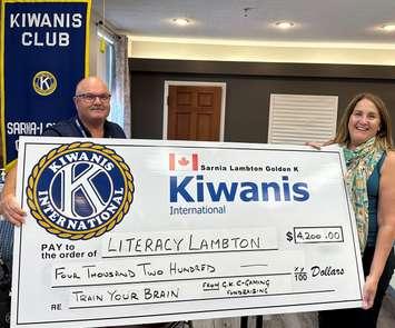 Tony Wheeler and Tracy Pound show off a $4,200 donation from Golden K Kiwanis to Literacy Lambton. July 2023. (Submitted Photo)