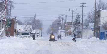 A snowmobile rides through a snow-covered street in Wyoming following the  "Snowmageddon" snowstorm. Dec 2010. (Photo by County of Lambton)