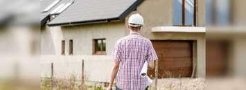 An engineer stands outside a  newly built house. June 27, 2017. (Photo from Pixnio)