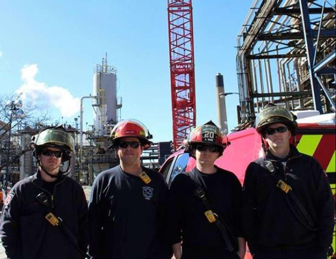 Imperial emergency responders Chris, Adam, Scott and Jeff stand in front of a crane brought in in the aftermath of a tower collapse April 2. Photo courtesy of Imperial Sarnia Site Facebook.