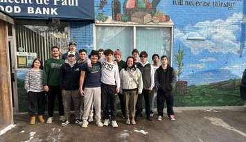 St. Pat's football team and coach Bennett Vani help unload boxes at St. Vincent de Paul food bank following 41st annual Irish Miracle. (submitted photo)