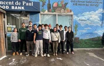 St. Pat's football team and coach Bennett Vani help unload boxes at St. Vincent de Paul food bank following 41st annual Irish Miracle. (submitted photo)