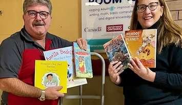 Inn of the Good Shepherd Executive Director Myles Vanni accepts books from Literacy Lambton Executive Director Tracy Pound. Submitted photo.