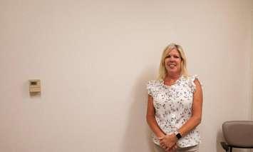 Tara Greenway, Sexual Assault/Domestic Violence Team Lead and Clinical Resource Nurse, standing in front of the mural wall (Image courtesy of Chatham-Kent Health Alliance)