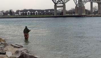 A fisherman waits for his big catch beneath the Bluewater Bridge's in Pt. Edward. BlackburnNews.com File Photo