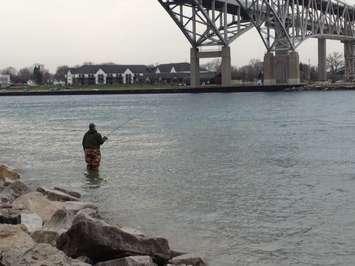 A fisherman waits for his big catch beneath the Bluewater Bridge's in Pt. Edward. BlackburnNews.com File Photo