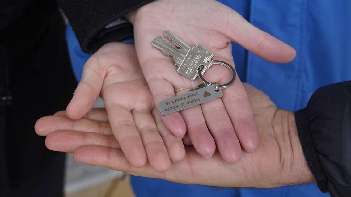 One of the new Habitat for Humanity homeowners holding the key for their new home (Photo by: Lindsay Newman/ Blackburn Media)