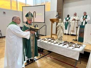 Bishop Ronald Peter Fabbro blessing the crosses at Sacred Heart Catholic School (Photo by: Lindsay Newman/ Blackburn Media)