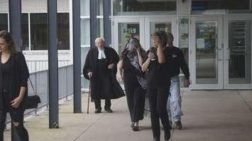 Karen Ebel-Savage leaves the Sarnia courthouse with a scarf covering her face alongside family and her defence counsel, David Stoesser. September 12, 2019. (BlackburnNews photo by Colin Gowdy)  