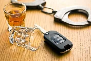 Alcohol, keys and police handcuffs depicting drinking and driving.  © Can Stock Photo / jirkaejc