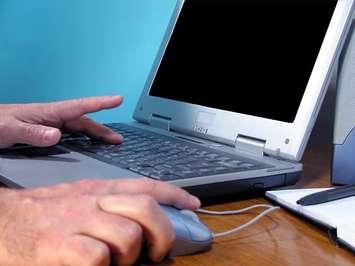 A person uses a computer. File photo courtesy of © Can Stock Photo / Razvanjp.
